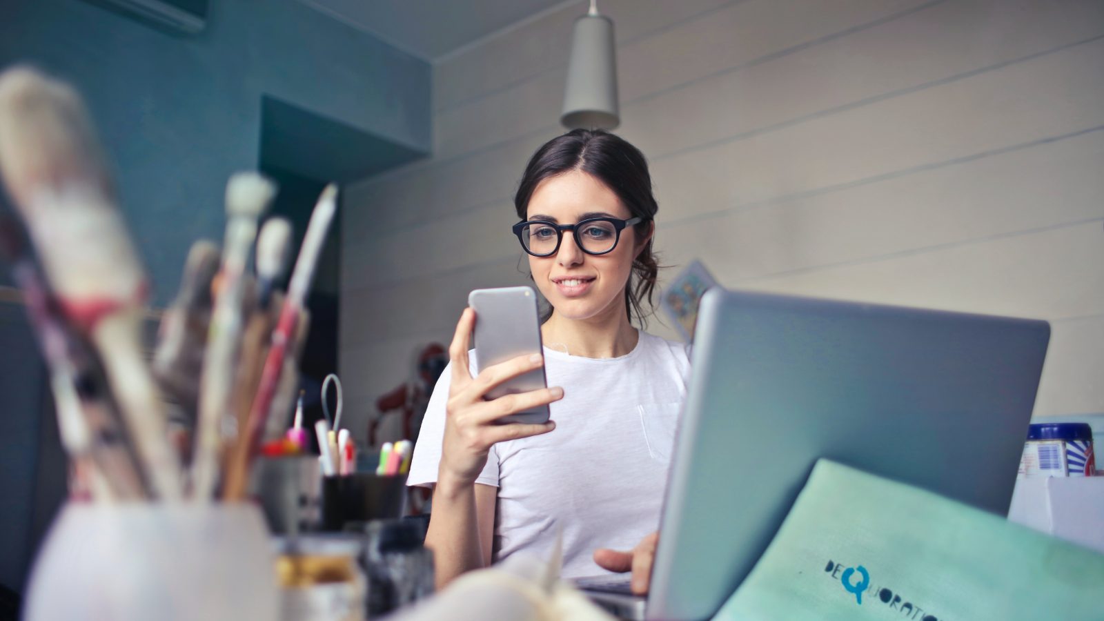 woman in white shirt using smartphone