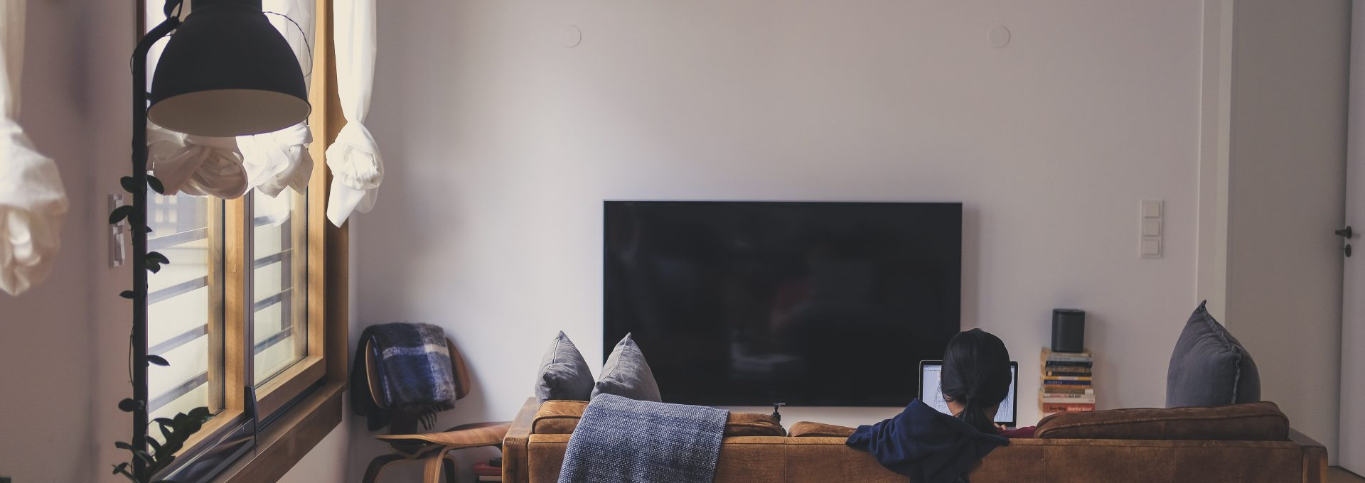 woman sitting on couch in front of LED TV