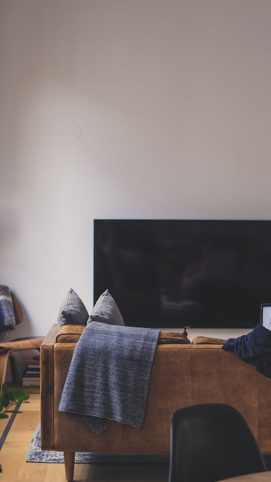 woman sitting on couch in front of LED TV